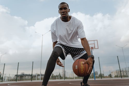 Free Man in White Crew Neck T-shirt dribbling Basketball Stock Photo