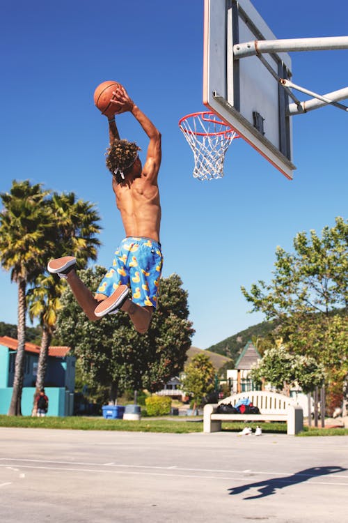 Free Man Wearing Blue and Yellow Shorts Playing Basketball Stock Photo