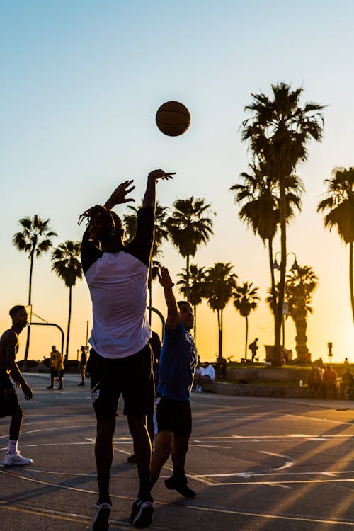 Free Man Shooting Basketball Into the Basketball Hoop Stock Photo