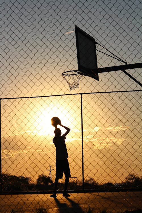 Free Basketball player throwing ball into basketball hoop Stock Photo